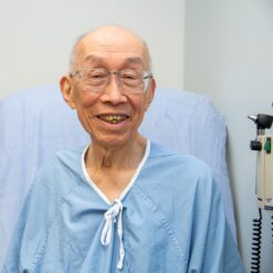 A smiling man in a hospital gown